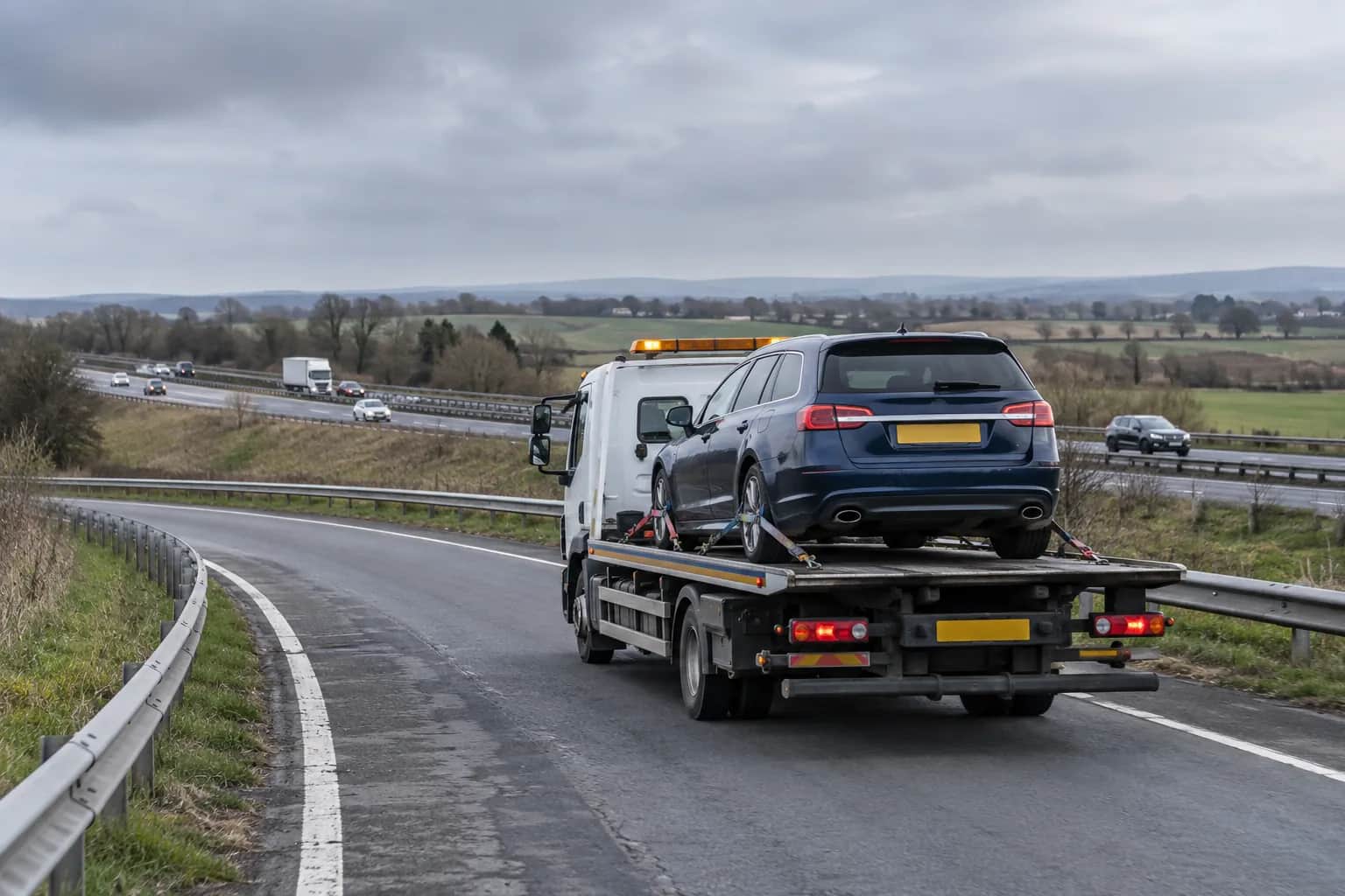 Car being loaded onto a flatbed recovery truck on a dual carriageway near the A1(M)